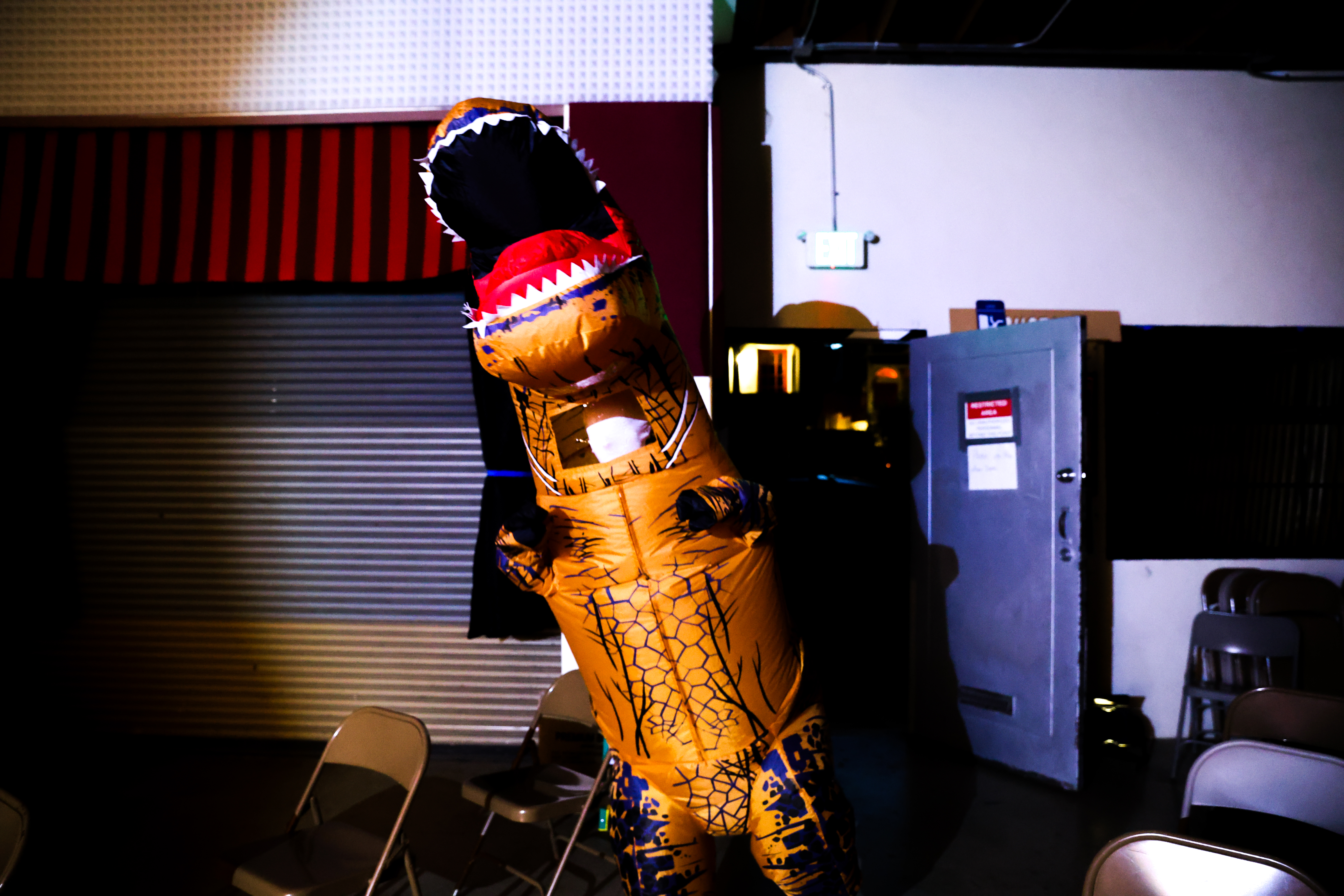 Anna in a white morphsuit inside a blow-up dinosaur costume.